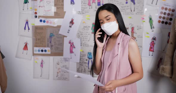 Fashion designer woman wears mask talking on mobile phone with customer alt