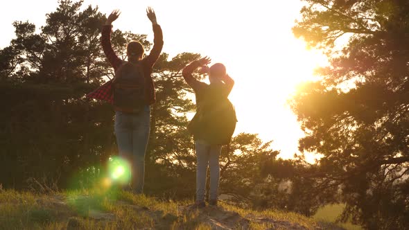 Two Girls Travel, Walk Through Forest and Wave Their Hands on Hill alt