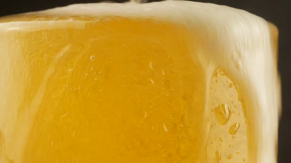 Close up background of pouring beer with bubbles and foam in glass