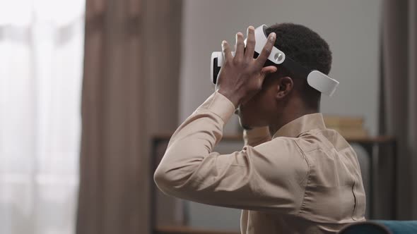 Young Afroamerican Man is Putting Off Headmounted Display and Looking at Reality Using Vr Glasses alt