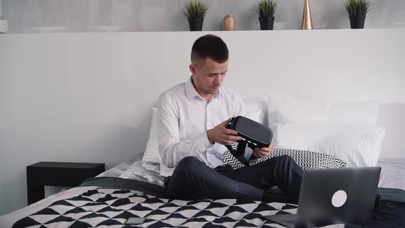 Man Is Sitting on Bed and Using New Digital Technology of Augmented Virtual Reality.