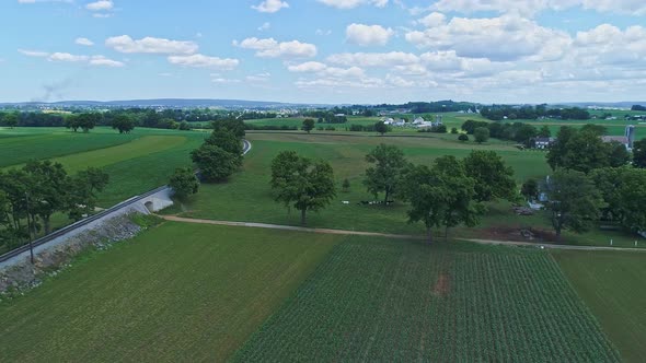 Aerial View of the Farm Countryside With Planted Fields and a Single Rail Road Track alt