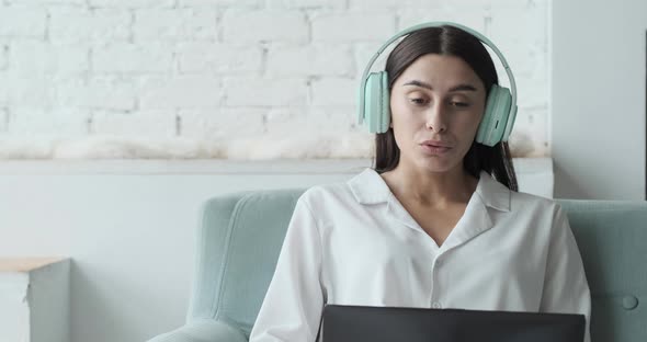 Young Woman Freelancer Talking with Client Making Video Remote Call and Writing Notes to Improve the alt