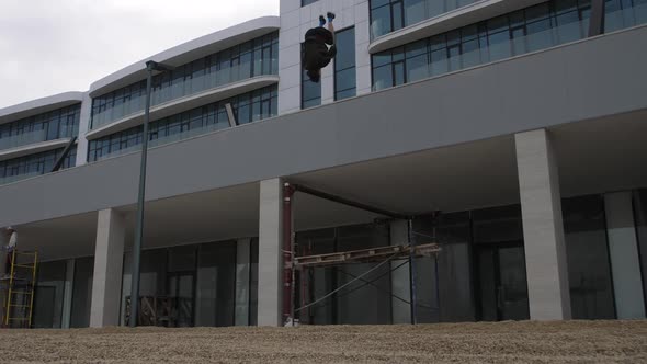 Young parker doing a crazy trick. Jumping somersaults from great heights alt