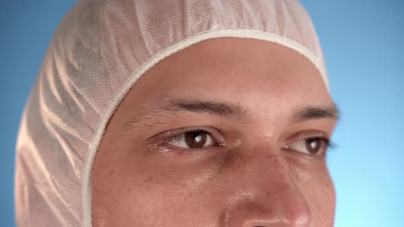 Caucasian Man in White Protective Suit Puts a Medical Mask on Face