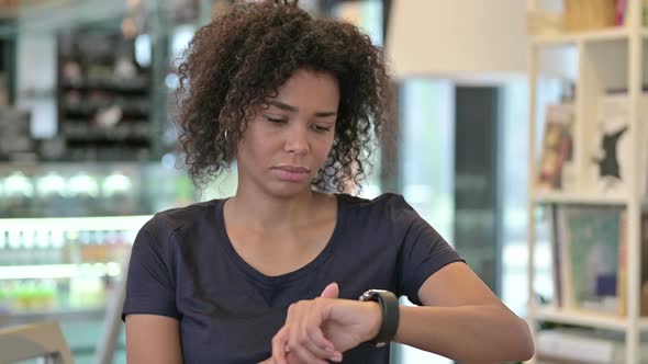 Portrait of Serious Young African Girl Using Smart Watch alt