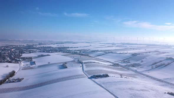 Snowy Fields And Community Near Wind Farm At Winter In Zistersdorf, Lower Austria. - aerial alt