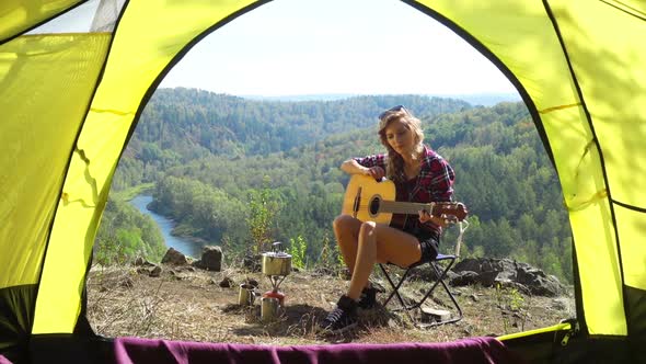 Woman Sitting On Camping Chair Above The River
