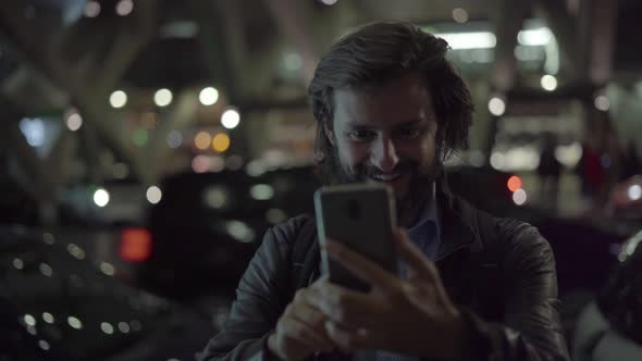 Smiling Man Waving and Making Video Call on Smartphone alt