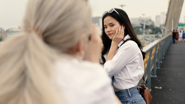 Asian lesbian couples enjoying traveling using film camera taking a photo.