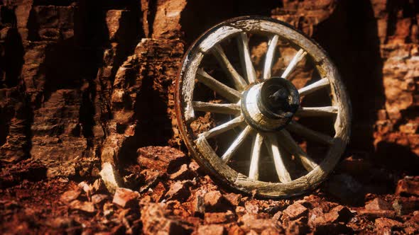 Old Wooden Cart Wheel on Stone Rocks alt