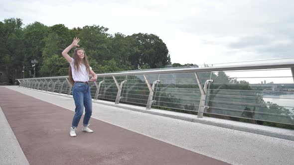 Beautiful Joyful Teenage Girl Dancing on Bridge alt