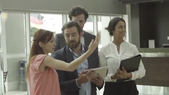 Business colleagues discussing plans in building lobby alt
