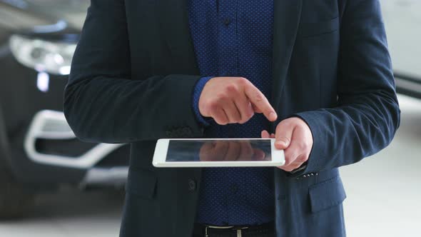 Image for Graphic Implements. A Man in a Business Suit Holds a Tablet