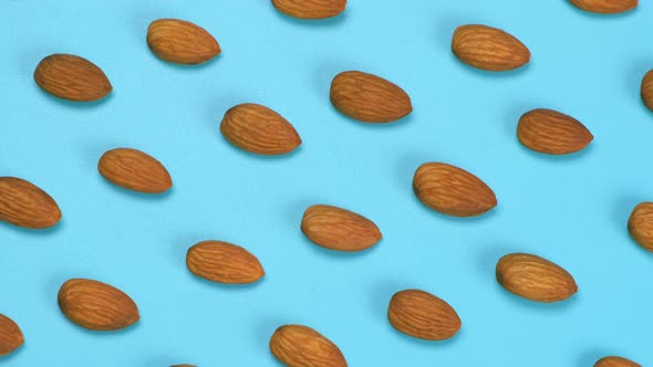 Rotating Blue Background with Nuts Almonds Close Up Top View