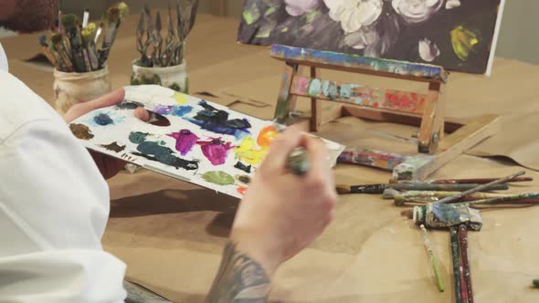 Shot of a Painter Squeezing Oil Paint on To His Palette alt