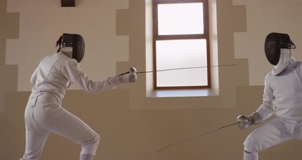 Fencer athletes during a fencing training in a gym alt