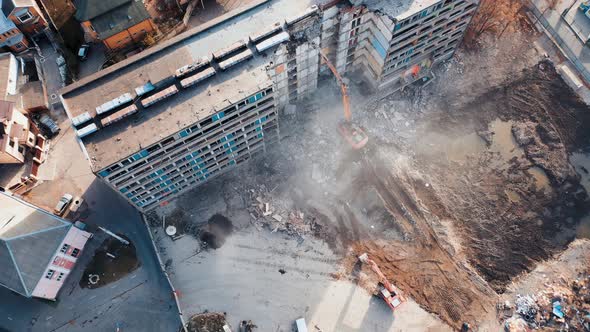 Aerial View Excavators Dismantle The Concrete Structures Of The Building. alt