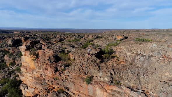 Male rock climber standing over a rocky mountain  alt