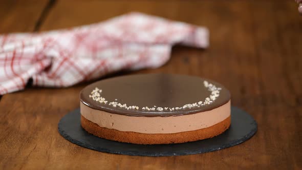 Woman Decorating And Sprinkling Nuts On Top Chocolate Mousse Cake.	 alt