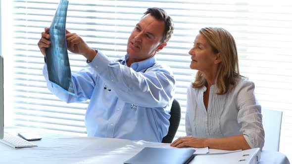 Doctor discussing a x-ray report with patient alt