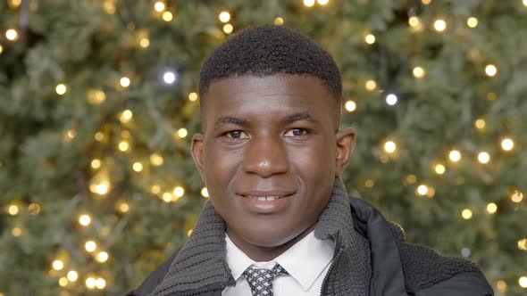 smiling black african businessman in the city at christmas time alt