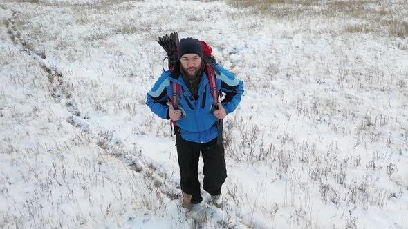 Lonely Hiker Walks Across an Endless Snow Field. alt