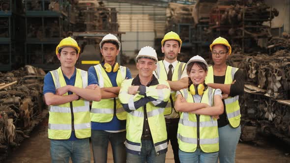 Various ethnics of engineers in uniforms and helmets in warehouse factory. alt