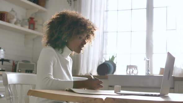 Student Studies at Distant Lesson with Notebook and Writes alt