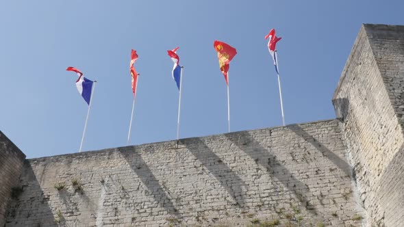 CAEN, FRANCE - JULY 2016 Famous flags of France and Normandy in city center castle slow motion  wavi alt