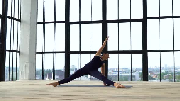 Athletic Fit Girl Stretching in Modern Studio with Big Windows alt