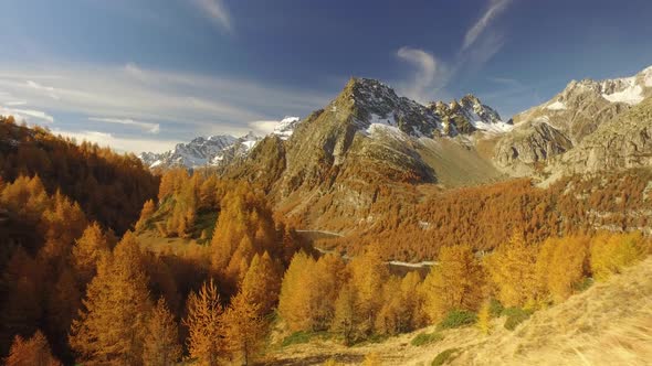 Side POV Walking on Fall Path with Woods Trees Lake and Snowy Mounts alt
