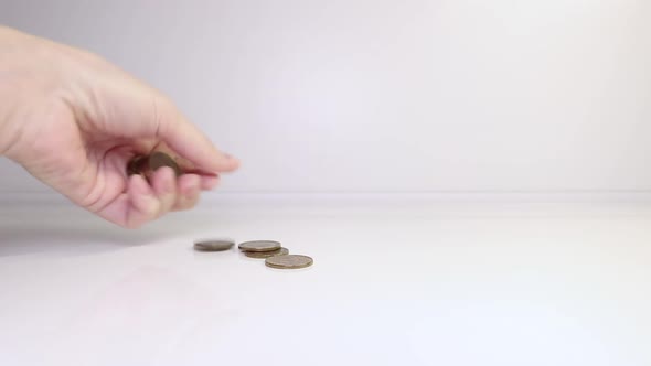 A woman's hand puts coins on the table and counts them. Investment concept. Metallic currency. alt