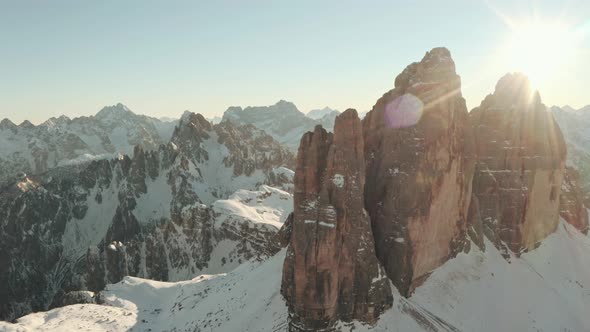 Drone shot over Tre Cime towards Candini group mountains in Winter alt