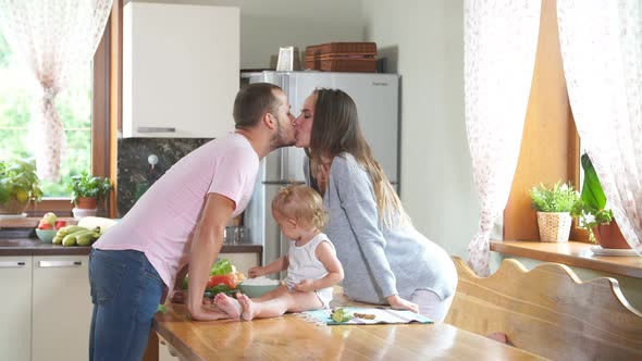 Young Family Kissing in the Kitchen