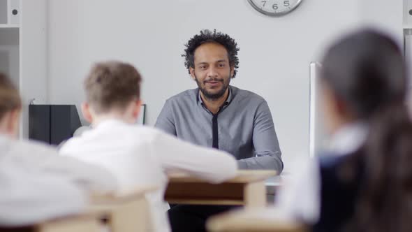 Charismatic Young Black Teacher Talking to Schoolchildren in Class alt