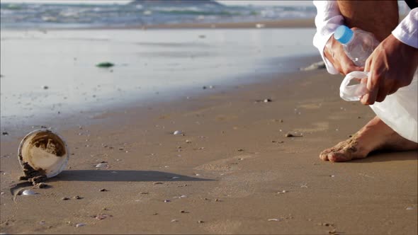 A Man Collects Plastic Garbage on the Beach