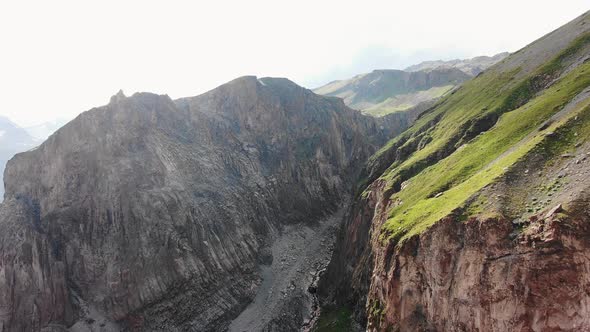 Big Brown Sharp Cliffs with Grass on Top and River in Canyon alt