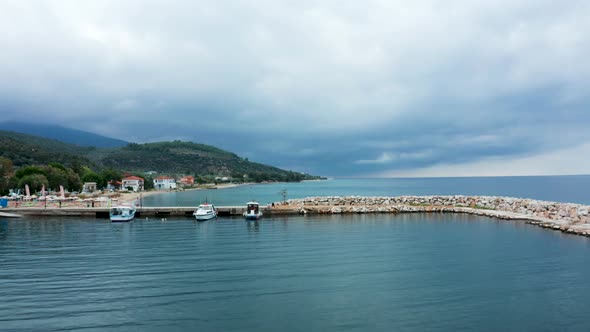 Drone Flying Over Ship on the Docks of Harbor with Blue Sea Water alt