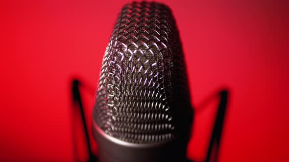 Studio Condenser Microphone Rotates on Red Background. alt