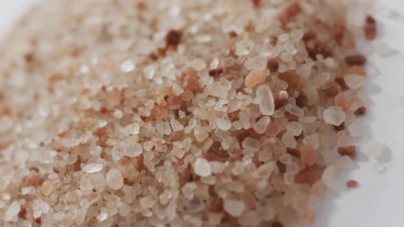 Video of pile of himalayan pink salt on white background alt
