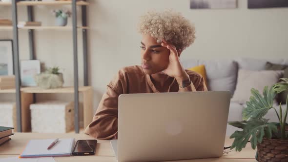 African Female Look at Laptop Screen Work Online Think of Problem Solution alt