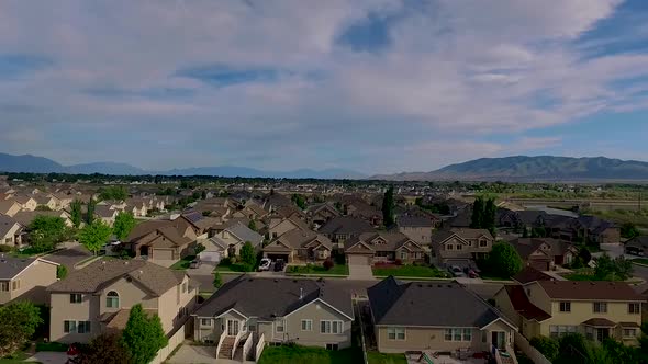 Aerial view of a suburban neighborhood with nice houses, back yards, nice lawns and trash cans along alt