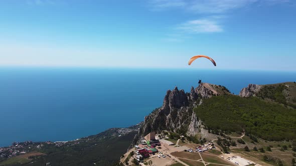 A Paraglider Flies on a Paraglider Against the Backdrop of the Beautiful Peaks alt