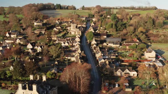 Aerial drone video of a Cotswolds Village Church, a rural scene in English countryside with houses alt