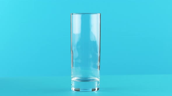  Close-up Shot of Milk Cold Beverage Drink Pooring Into Glass Blue Background in Studio alt