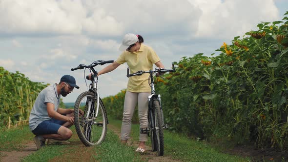 Guy Repairing a Bicycle His Girlfriend alt