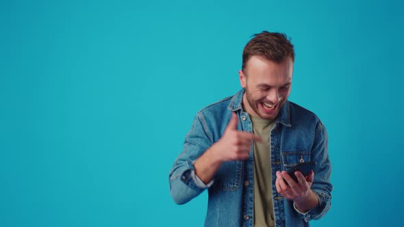 Happy Man Typing Sms on Blue Background