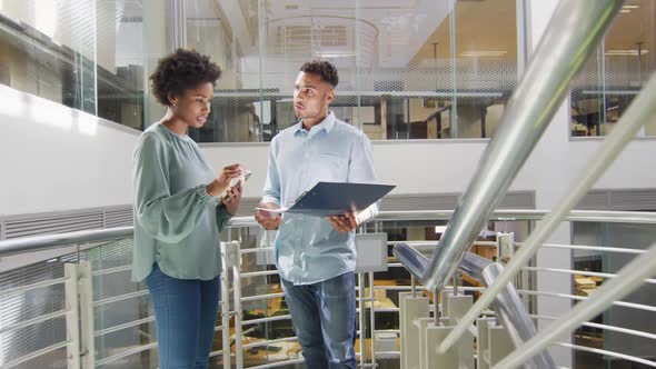 Video of diverse businessman and businesswoman talking on staircase alt