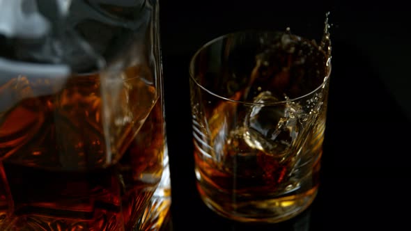 Super Slow Motion Shot of Ice Drop Into Glass with Whiskey at 1000Fps with Camera Movement alt